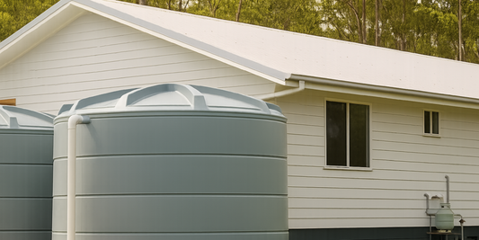 Water storage tanks beside a house for rainwater harvesting and water supply