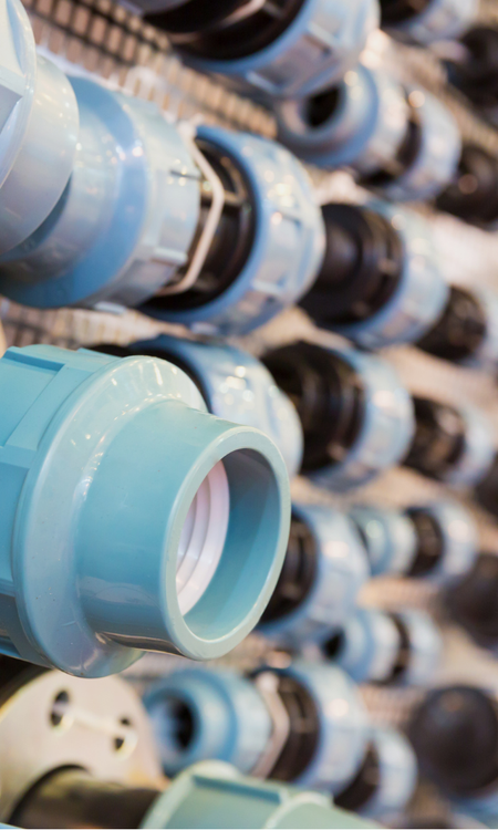 A large group of plastic fittings on display in supply store setting